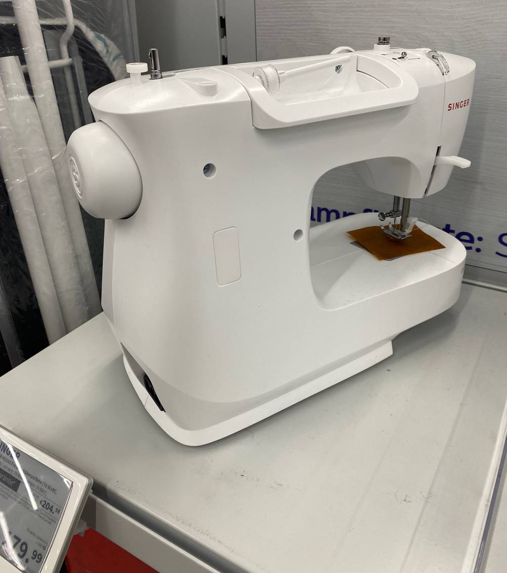 Nähmaschinen für Anfänger-Test: eine weiße Nähmaschine stehend in einem Regal mit Preisschild ersichtlich.