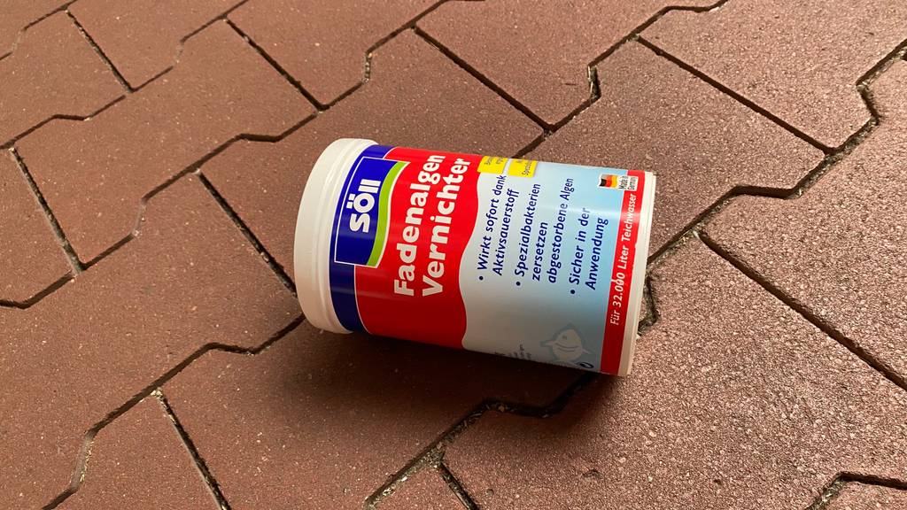 Auf einem Steinboden liegt eine Dose getesteter Fadenalgenvernichter.