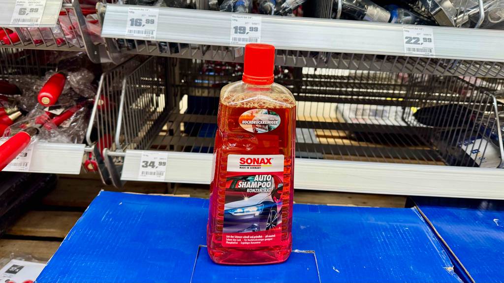 Das getestete Autoshampoo steht vor einem Regal.
