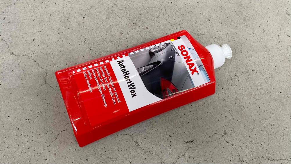 Auto-Hartwachs im Test: Eine Flasche liegt quer auf einem Steinboden