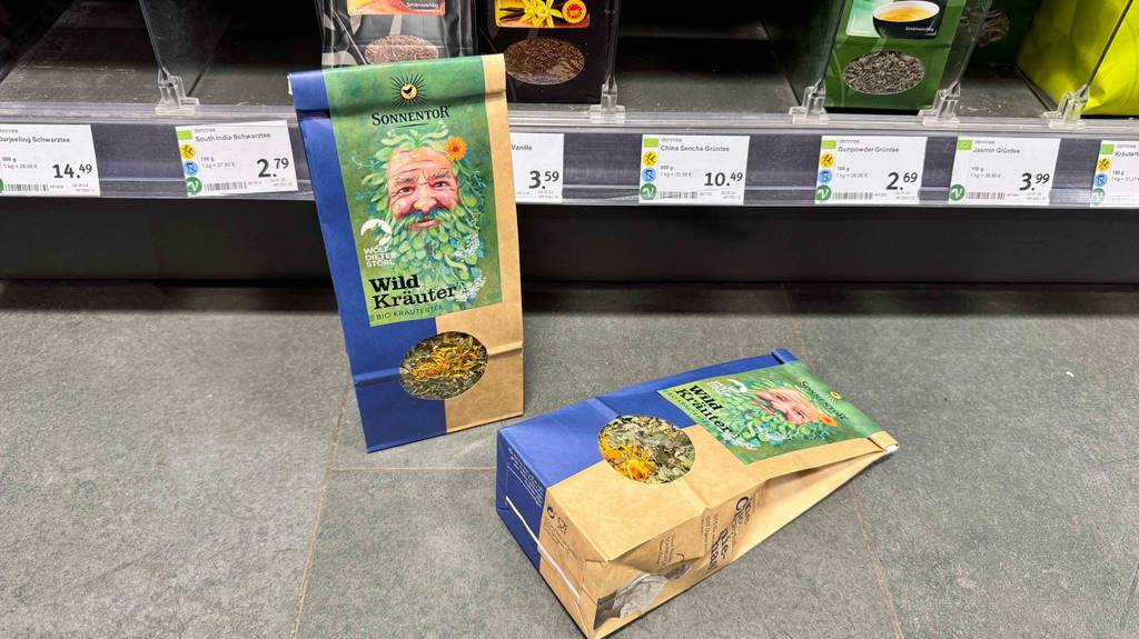 Test: Eine liegende und eine stehende Packung des Bio-Kräutertees, die vor einem Regal platziert sind.