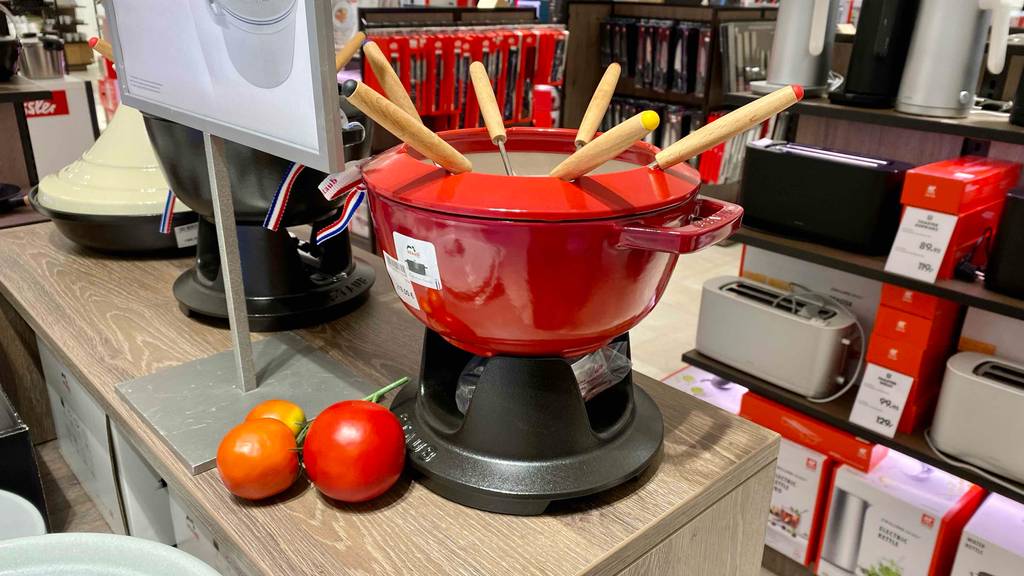 Käsefondue getestet: ein Käsefondue in Rot mit Stäbchen darin steht in einem Geschät.