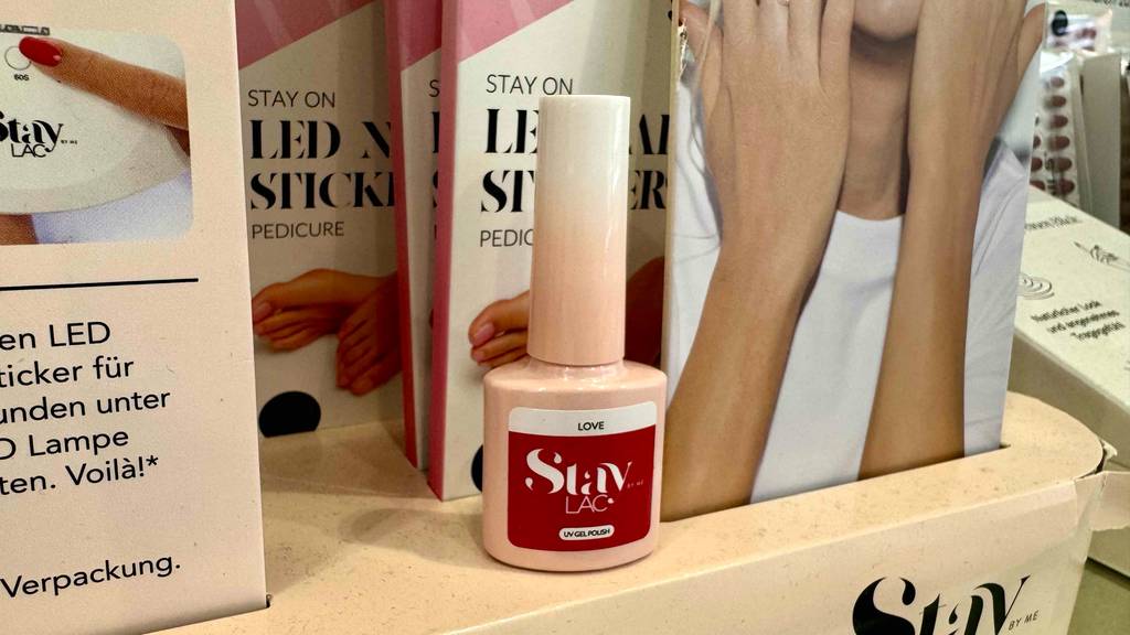 Ein getestetes UV-Gel in der Farbe Rot ist vor einem Aufsteller platziert.