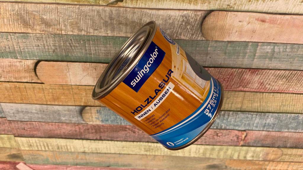 Holzlasur getestet: Eine Dose Lasur liegt kopfüber auf einer Holzoberfläche