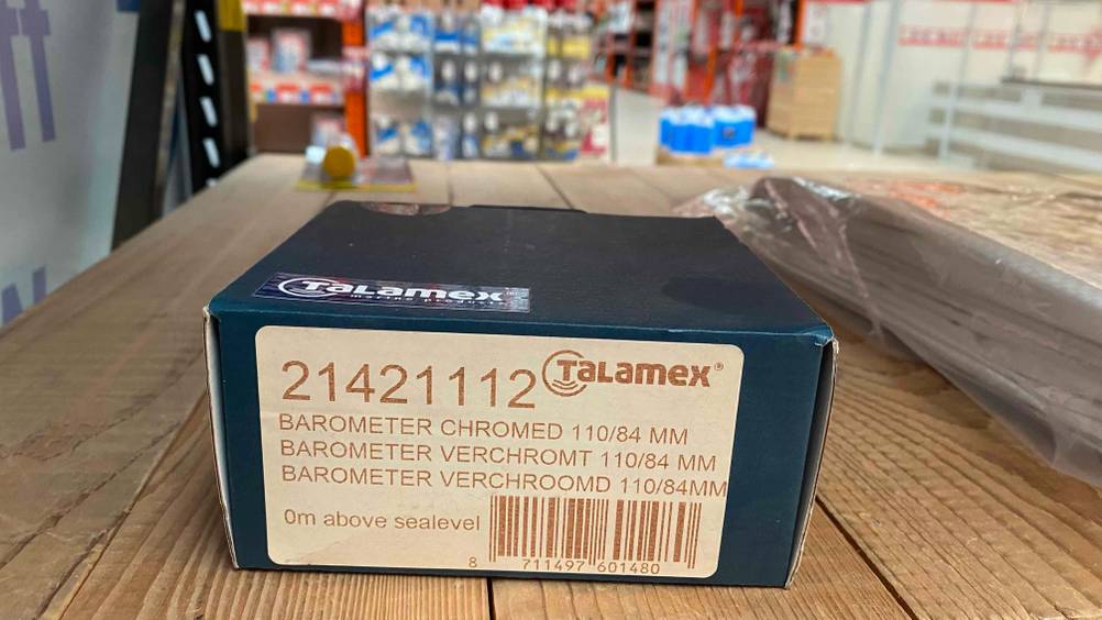 Im Test: Ein verpacktes Barometer liegt auf einer Holzfläche.