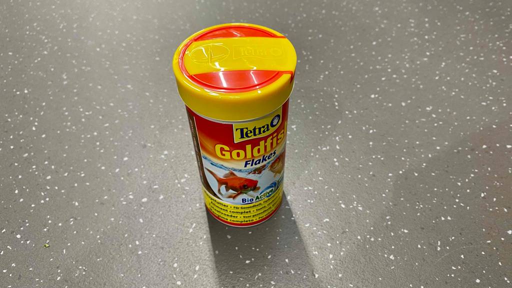 Goldfischfutter getestet: verschlossene Dose Goldfischfutter stehend auf einem grauen Boden.