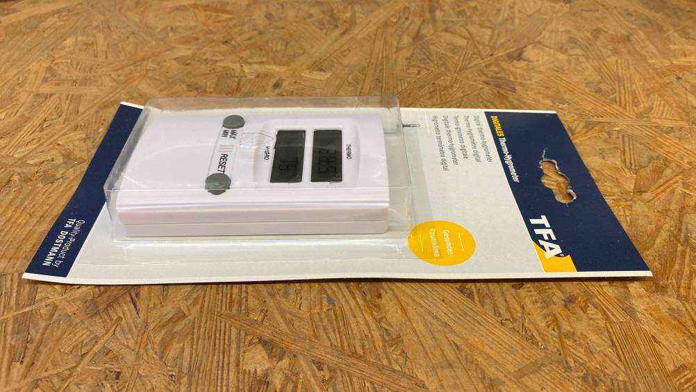 Hygrometer getestet: Ein verpacktes Gerät liegt horizontal auf einer Holzoberfläche