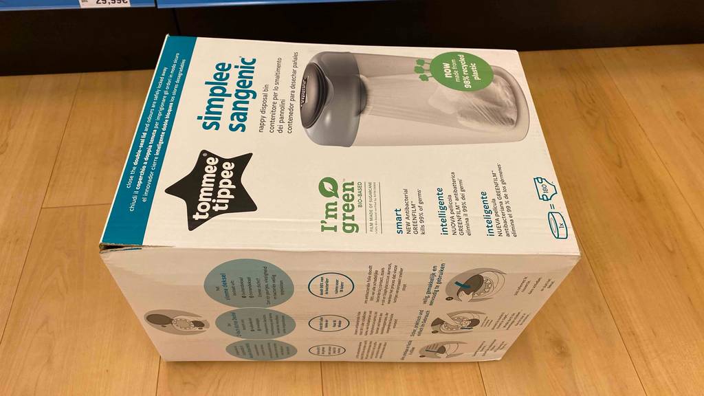 Windeleimer getestet: Auf einem Holzboden liegt ein verpackter Windeleimer horizontal.
