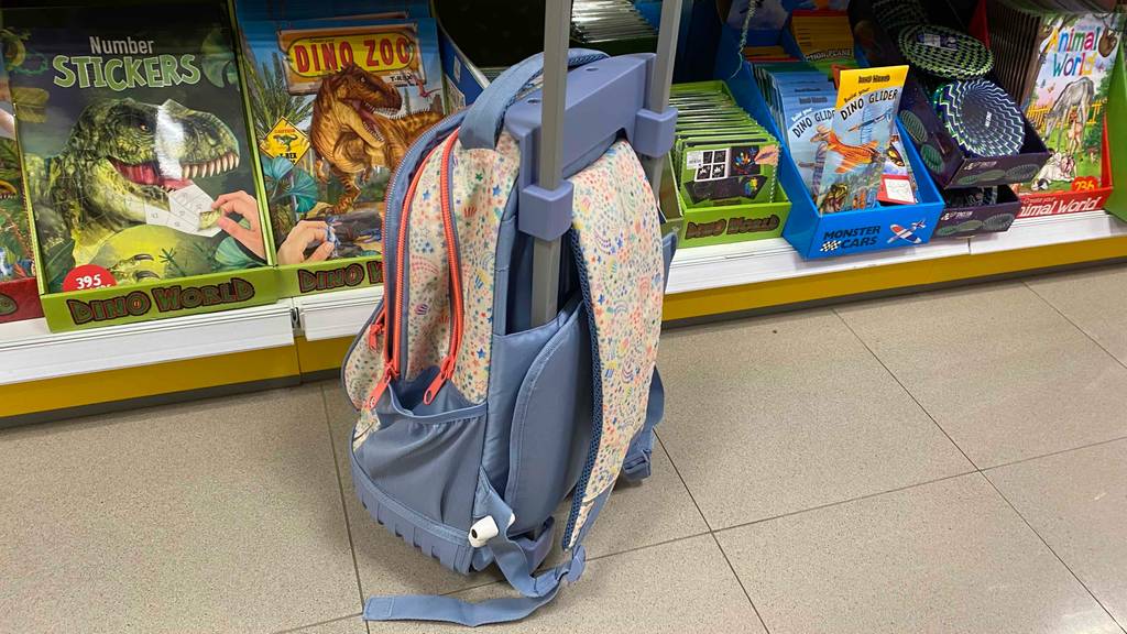 Der getestete Schultrolley von schräg hinten vor einem Regal mit anderen Produkten