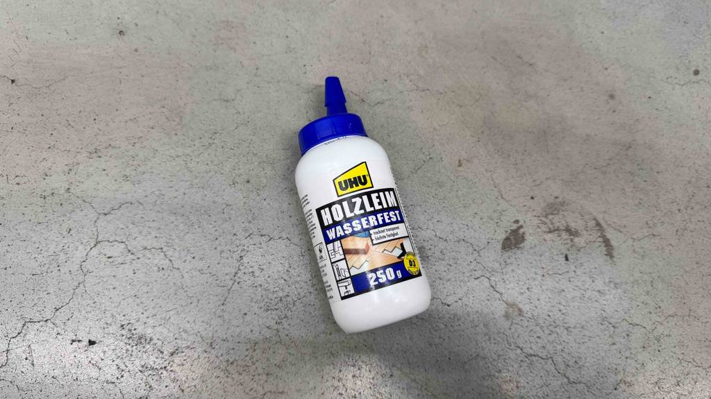 Test: wasserfester Holzleim liegend auf einem Boden mit 250 g Inhalt.