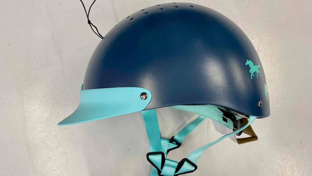 Reithelm im Test: Ein blauer Reithelm von der Seite inklusive Gurte