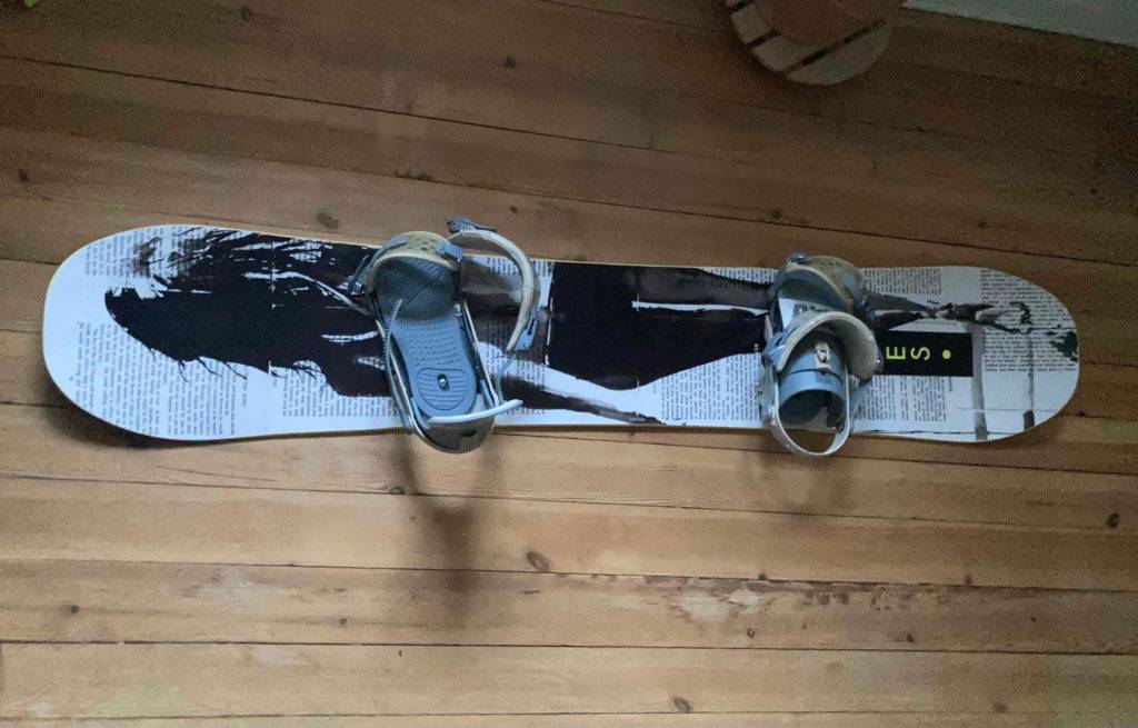 Ein getestetes Snowboard steht auf einem Holzboden.