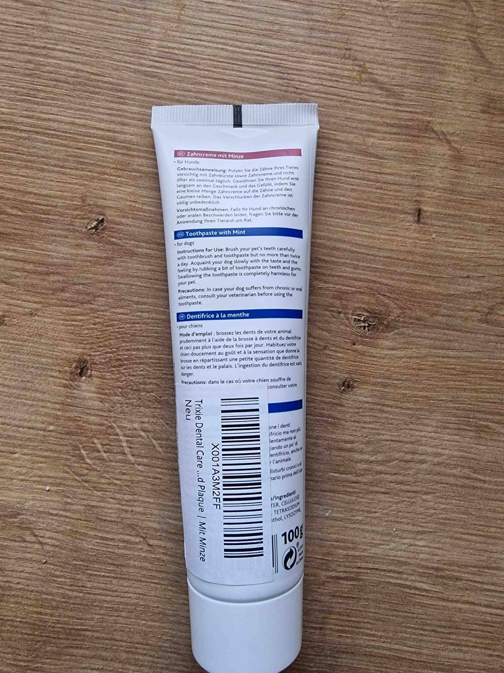 Im Test: Eine Tube Zahnpflege (Hund) liegt mit der Rückseite nach oben auf einer Holzfläche