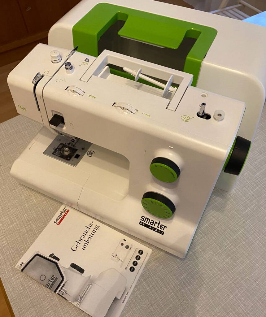 Nähmaschine getestet: eine weiße Nähmaschine mit der Bedienungsanleitung daneben ersichtlich.