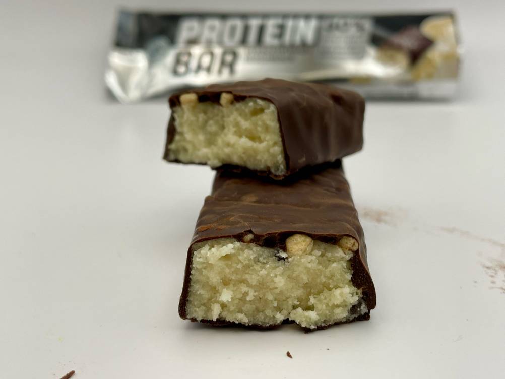 Ein auseinander gebrochener Weider-Proteinriegel, worauf sich ein Stück auf dem anderen befindet.