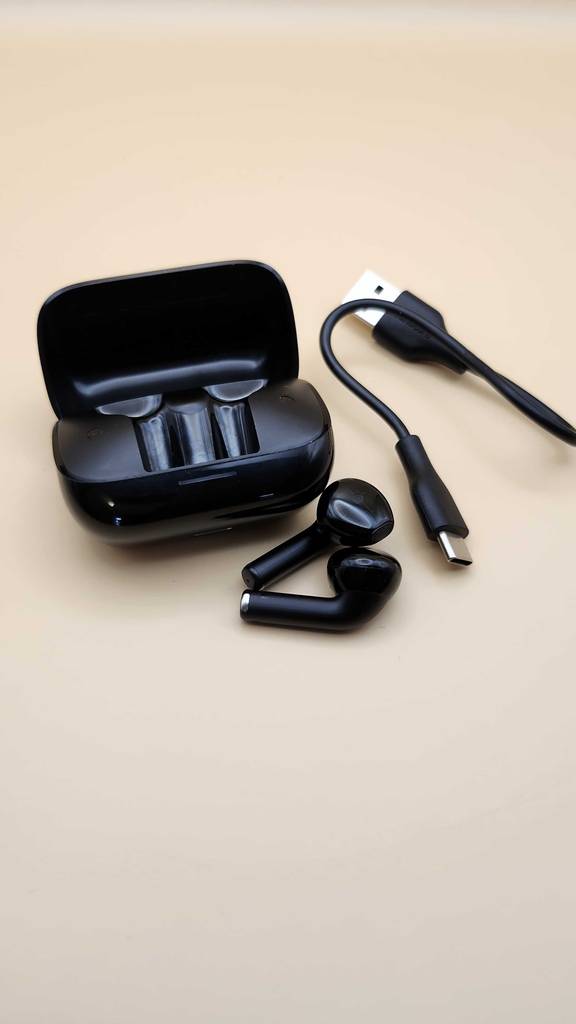Ladekabel, Case und die getesteten AKG-Kopfhörer liegen auf einer hellen Fläche.