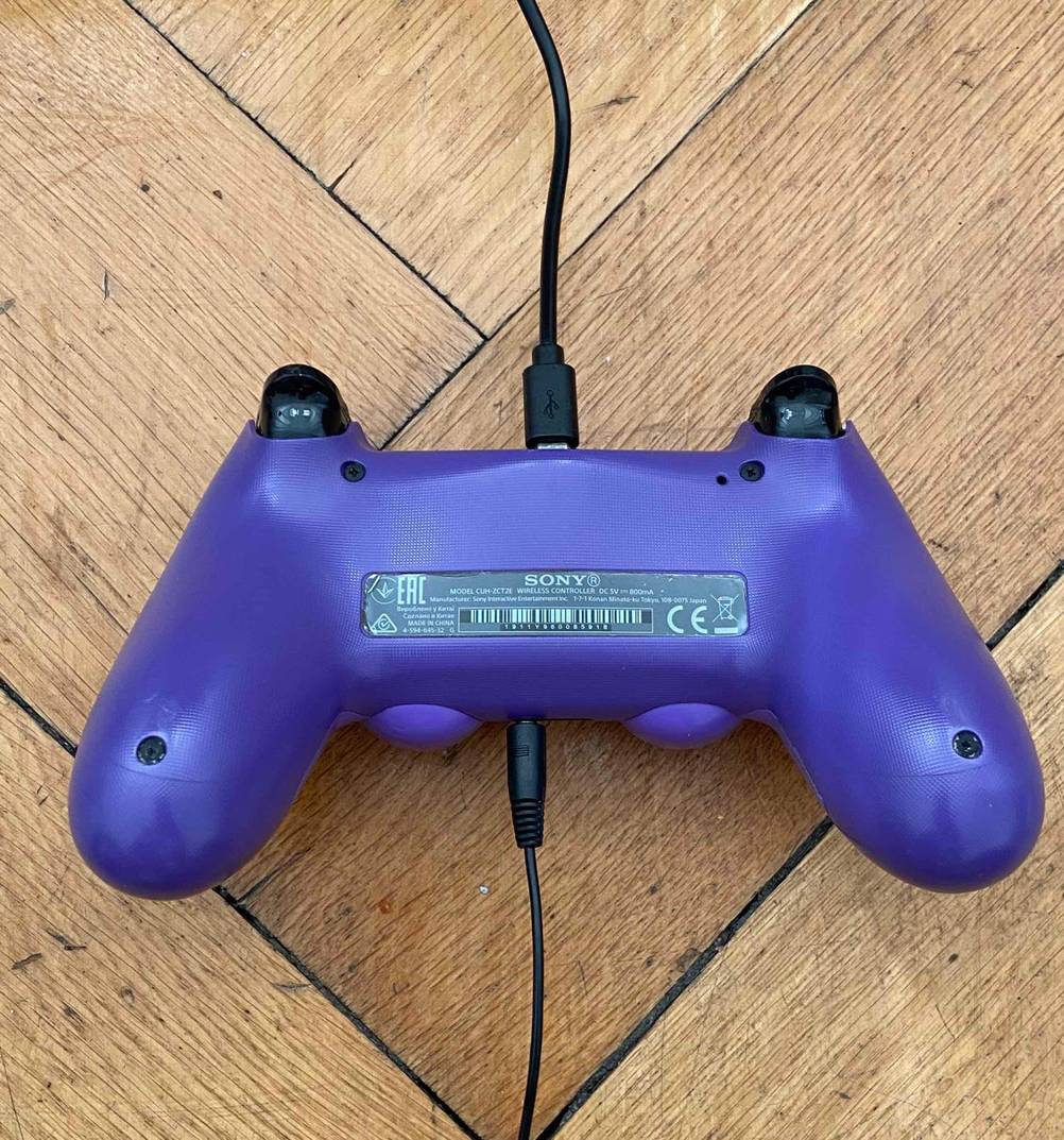 PS4-Controller getestet: ein PS4-Controller mit zwei angeschlossenen Kabeln auf dem Boden platziert.