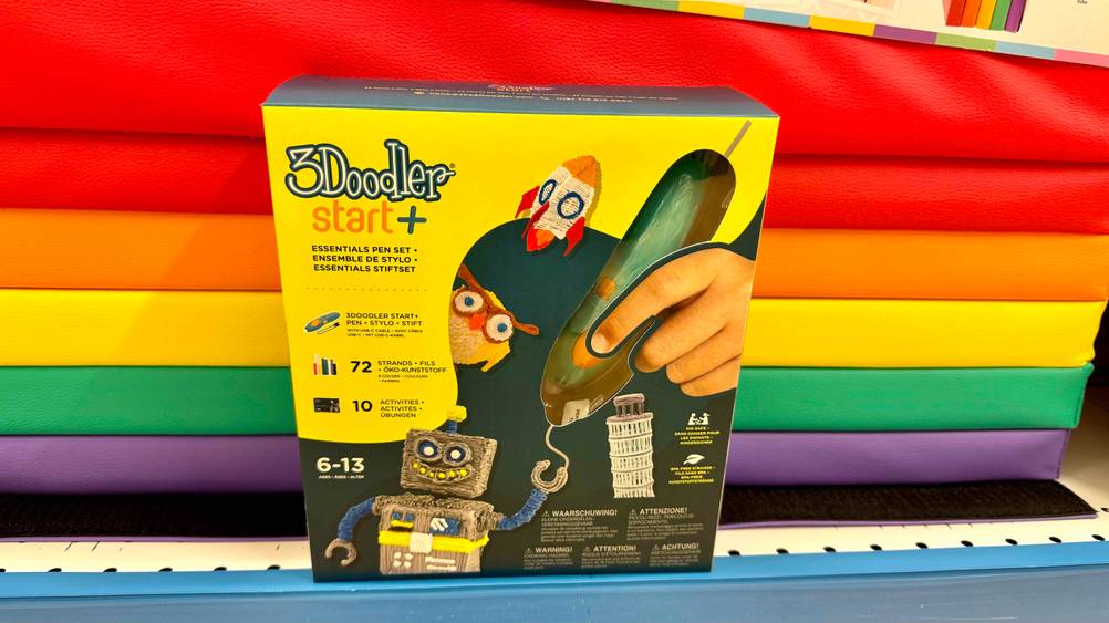 Ein originalverpackter 3D-Stift im Test vor einer bunten Wand.