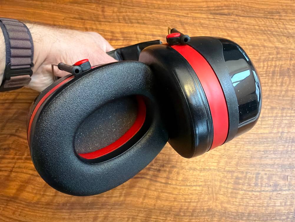 Eine Hand hält den 3M Peltor Optime III Gehörschutz fest.