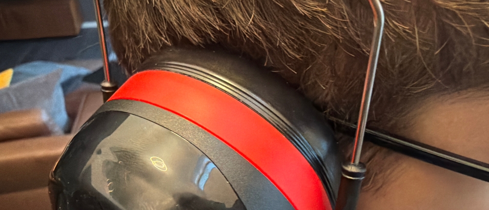 Eine Person mit Brille trägt den 3M Peltor Optime III.