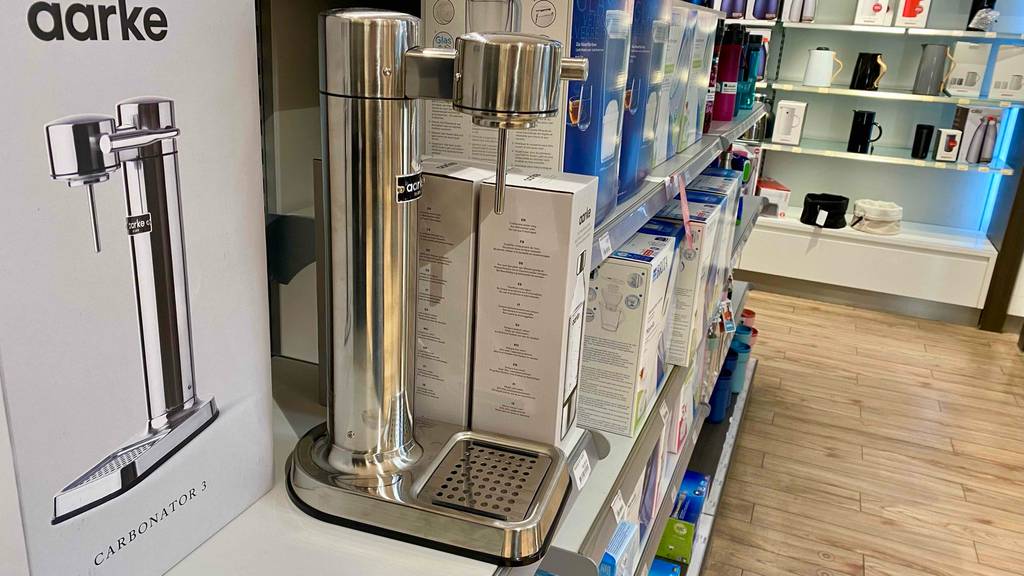 Wasserspender getestet: ein Wasserspender steht in einem Geschäft in einem Regal neben den Verpackungen.