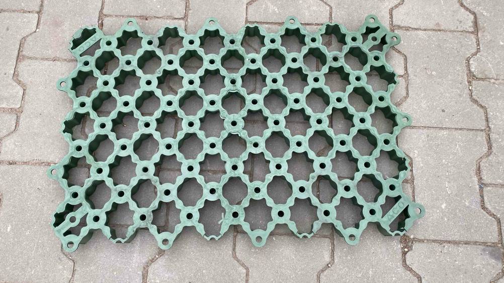 Rasengitter getestet: Ein grünes Rasengitter liegt auf einem Boden.