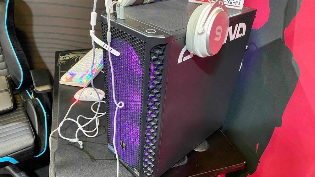 Gaming-PC im Test: Ein lila beleuchteter Computer von der Seite, im Hintergrund Maus und Tastatur