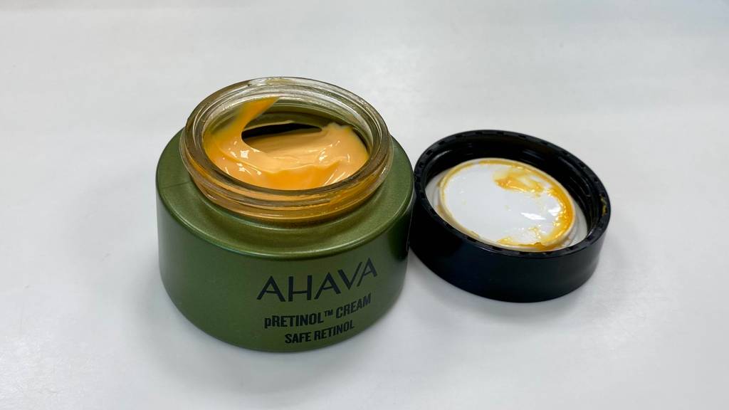Retinol-Creme-Test: Creme-Tiegel geöffnet, mit goldfarbener Creme darin.