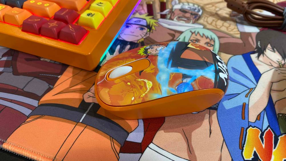 Bluetooth-Gaming-Maus getestet: Eine bunte Maus seitlich liegt neben einer bunten Tastatur auf einer bunten Oberläche