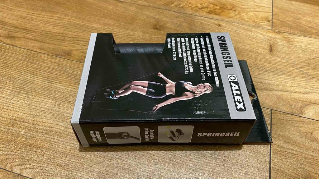 Springseil-Test: Verpackung von Springseil liegt auf einem Boden mit schwarzem Springseil darin.