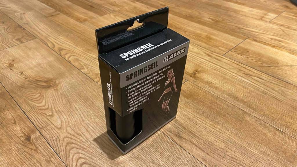 Springseil im Test: stehende Verpackung von Springseil steht auf einem Holzboden.