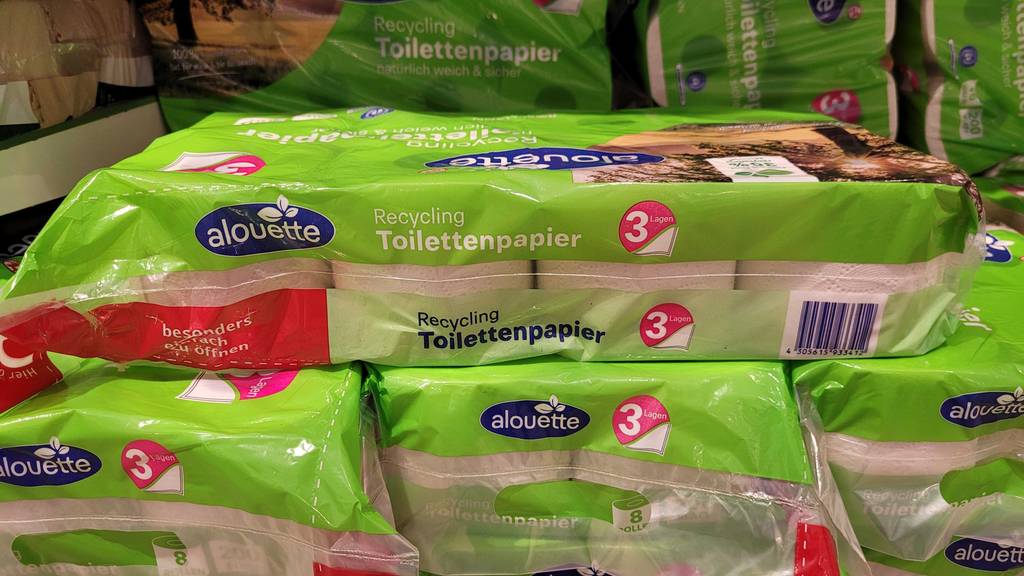 Verpackung des getesteten Recycling-Toilettenpapiers von der Seite, das auf weiteren Klopapierpackungen platziert ist.