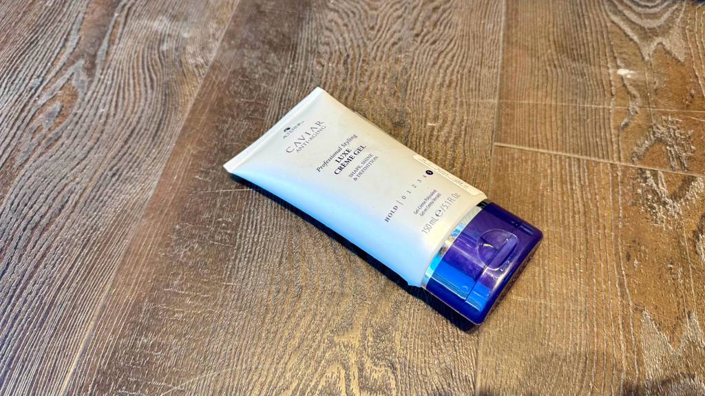 Die getestete Styling-Creme liegt auf einer Holzfläche.