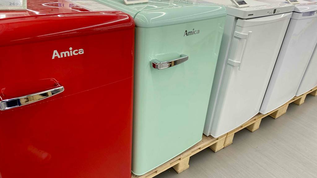 Retro-Kühlschrank-Test: ein roter und türkisfarbener Retro-Kühlschrank der Marke Amica stehend neben anderen Modellen.