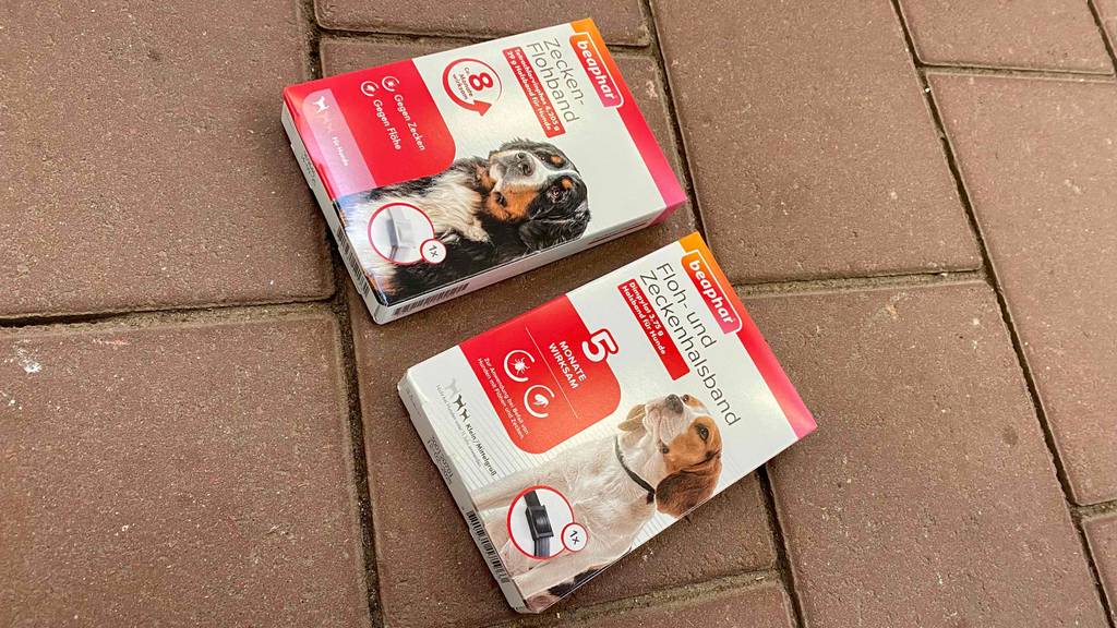 Zwei unterschiedliche Packungen des getesteten Zeckenhalsband für Hunde auf einem Steinboden