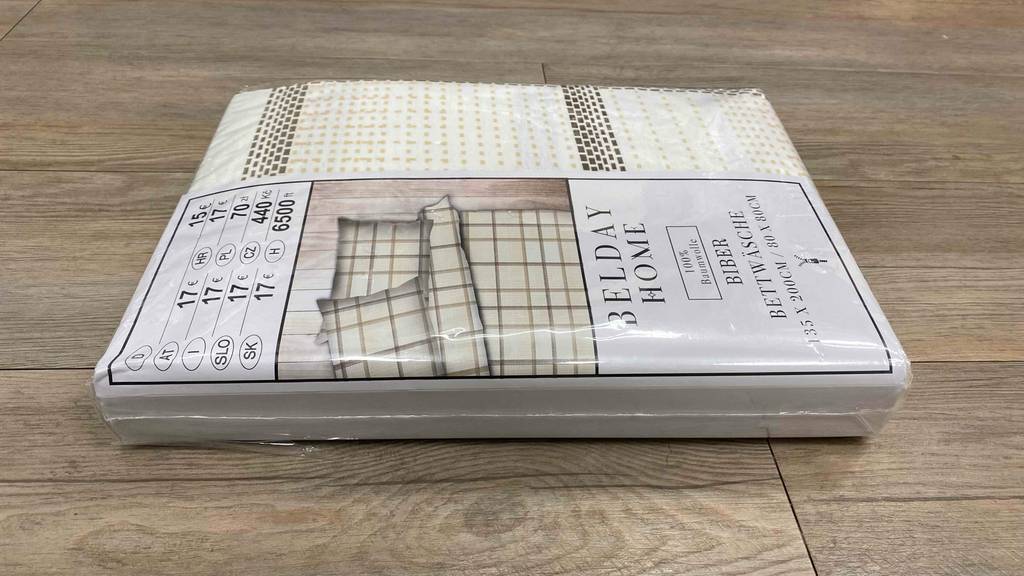 Biber-Bettwäsche-Test: Eine verpackte Biber-Bettwäsche von der Seite auf einem Holzboden liegend.