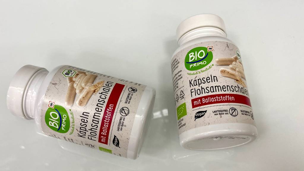 Flohsamenschalen-Kapseln getestet: Zwei Packungen liegen nebeneinander auf heller Oberfläche