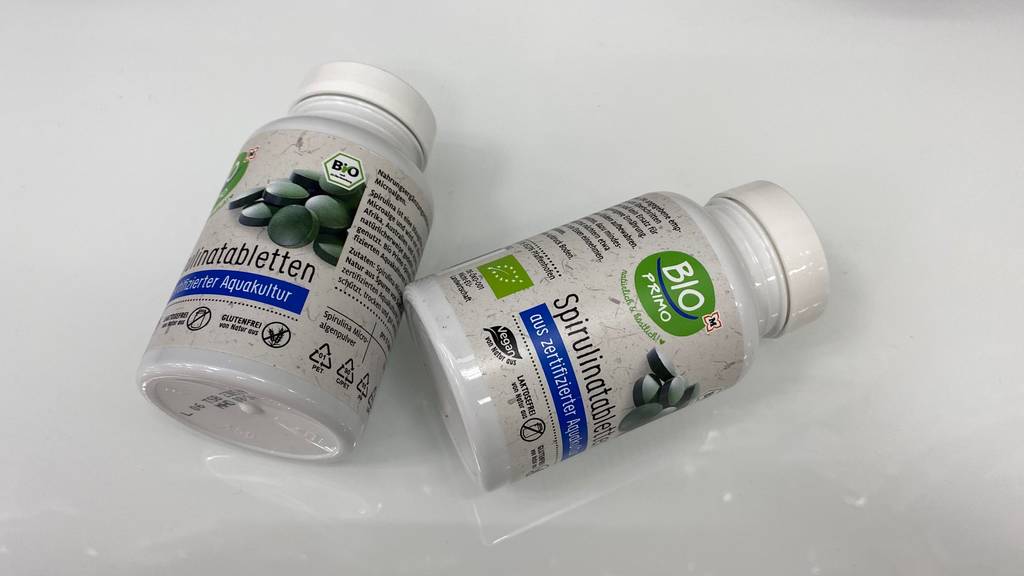 Spirulina-Tabletten im Test: Zwei Packungen liegen nebeneinander auf heller Oberfläche