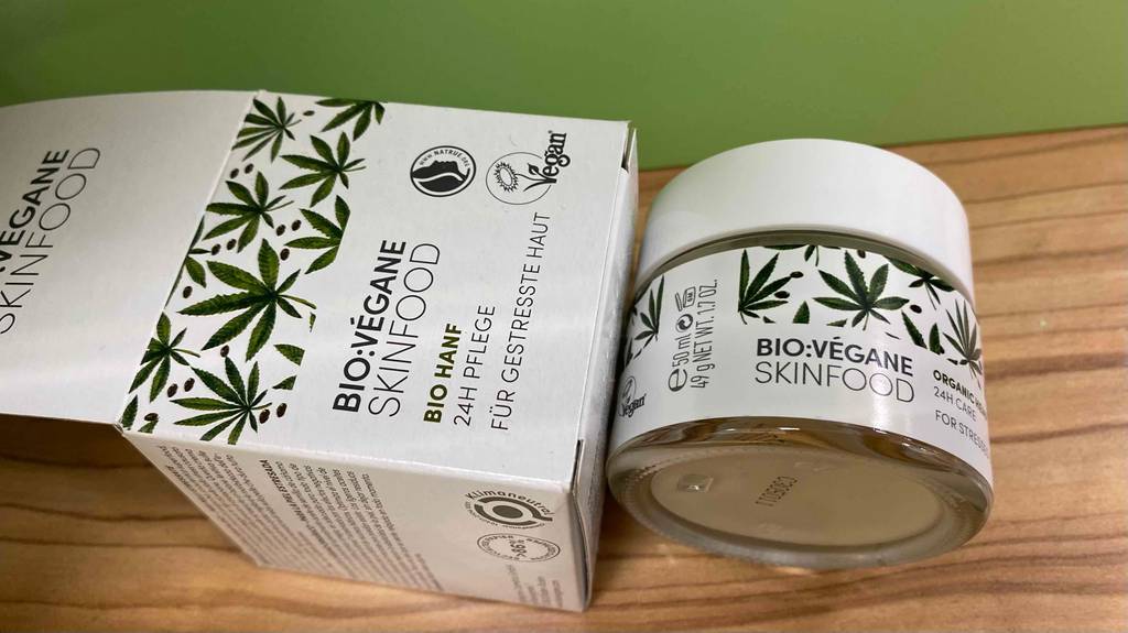 Hanfcreme und Verpackung von der Seite auf Holzunterlage
