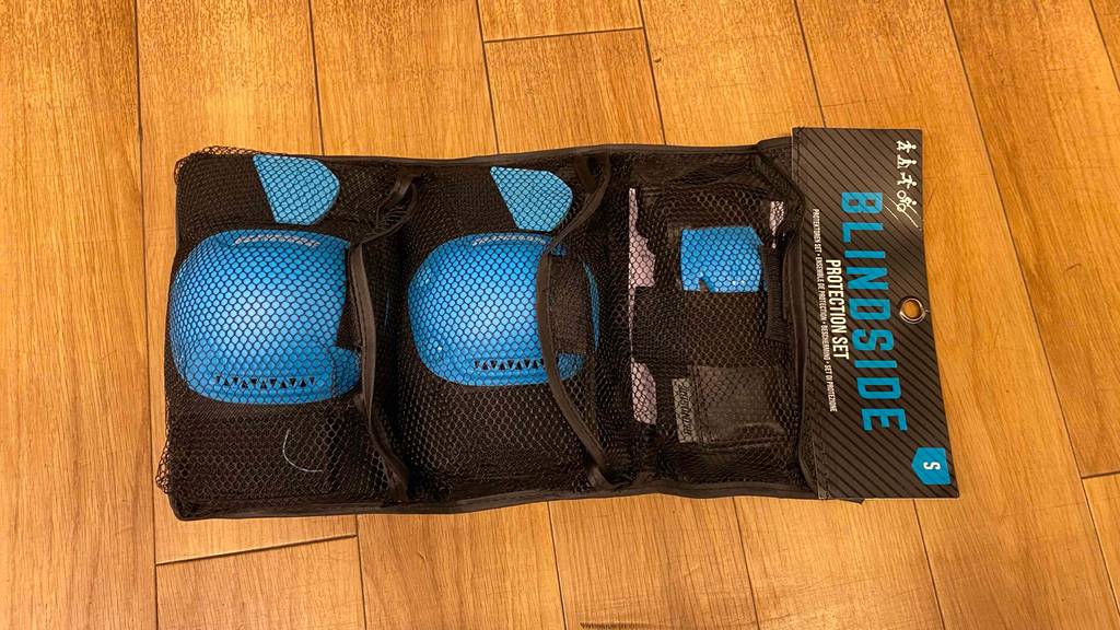 Protektoren für Kinder getestet: Ein Paar in Verpackung auf einem Holzboden.