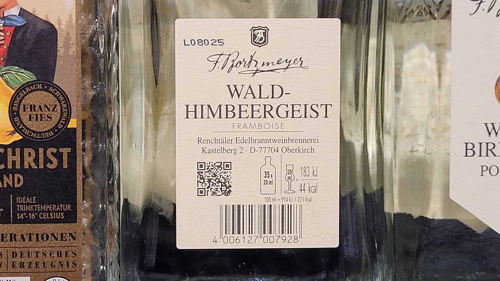 Himbeerlikör-Test: Nahaufnahme des Etiketts mit Produktangaben auf einer transparenten Flasche mit Wald-Himbeergeist.