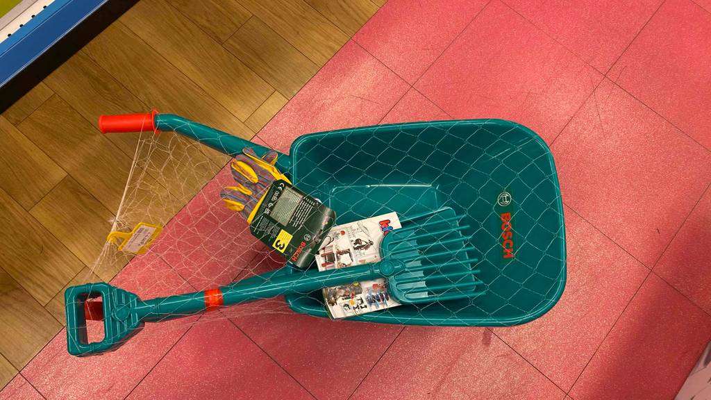 Im Test: Auf einem roten Boden steht eine Kinderschubkarre.