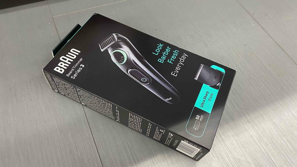 Im Test: Ein verpackter Braun-Barttrimmer liegt quer auf einem grauen Boden.