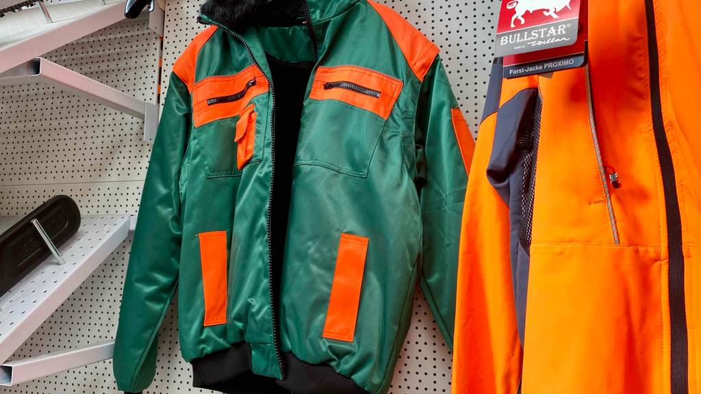 Eine getestete Schnittschutzjacke hängt im geöffneten Zustand auf einem Kleiderbügel.