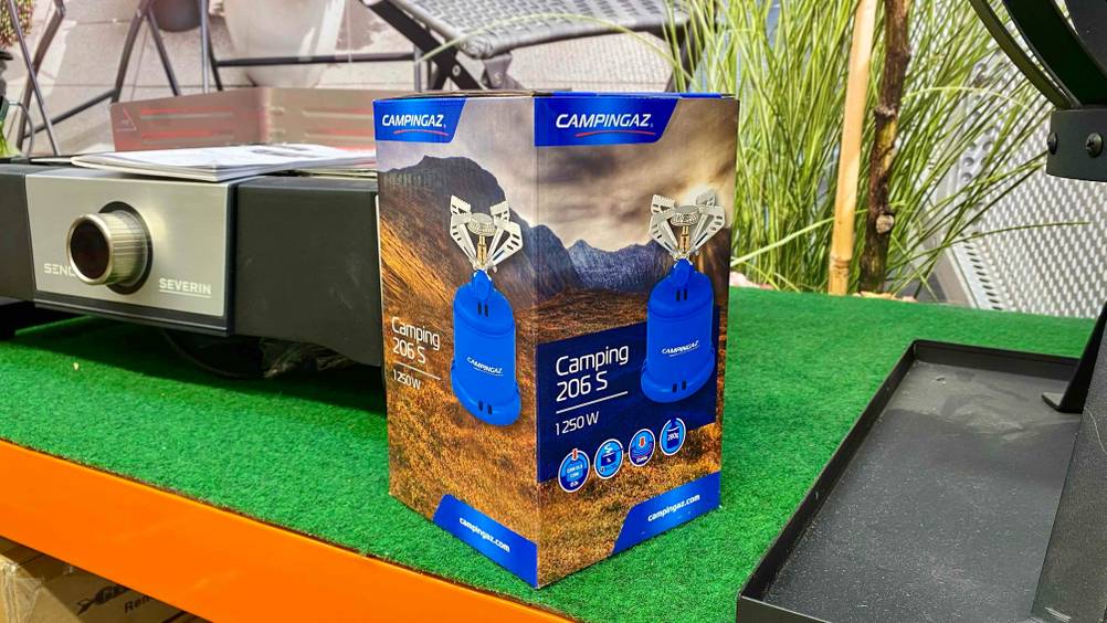 Getesteter Campingaz-Gaskocher steht verpackt auf einer grünen Fläche.