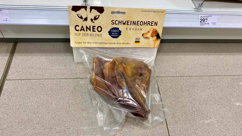 Schweineohren für Hunde getestet: Eine Packung Schweineohren lehnt an einem Regal.