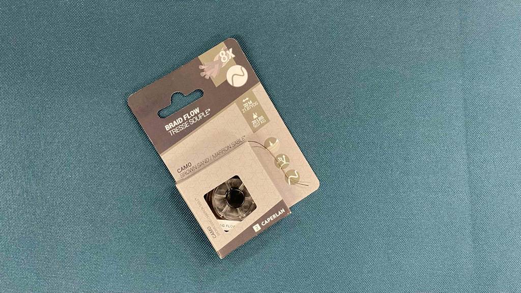 Geflochtene-Angelschnur-Test: die Verpackung von einer geflochtenen Angelschnur mit acht Stück darin liegend auf einem blauen Untergrund.