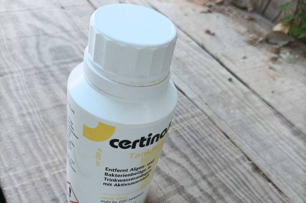 Eine Flasche getesteter Frischwassertank-Reiniger steht auf einer Holzfläche.