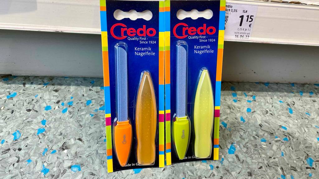 Keramik-Nagelfeile im Test: zwei Keramik-Nagelfeilen verpackt in der Farbe Gelb und Orange an einem Regal angelehnt.