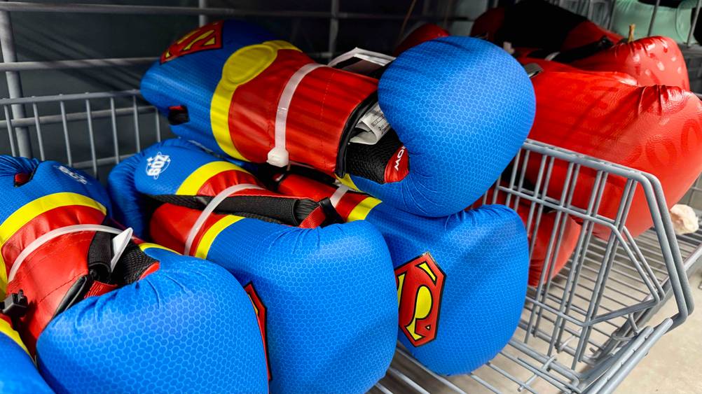 Kinder-Boxhandschuhe -Test: Mehrere Kinder-Boxhandschuhe liegen in einem Korb eines Geschäfts.